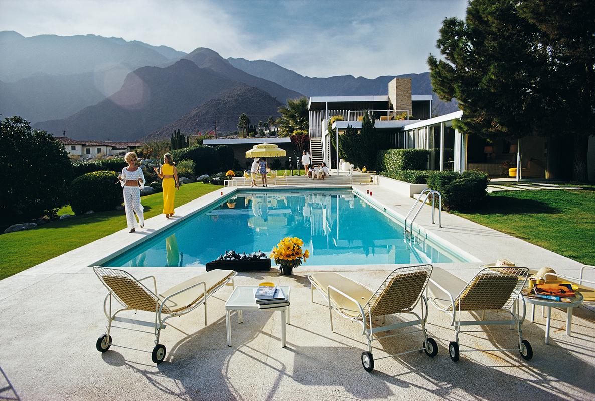 'Poolside Catwalk' 

Former fashion model Helen Dzo Dzo Kaptur (in white lace) and Nelda Linsk (in yellow), wife of art dealer Joseph Linsk, at the Kaufmann Desert House in Palm Springs, California, January 1970. The Linsks are the current owners of
