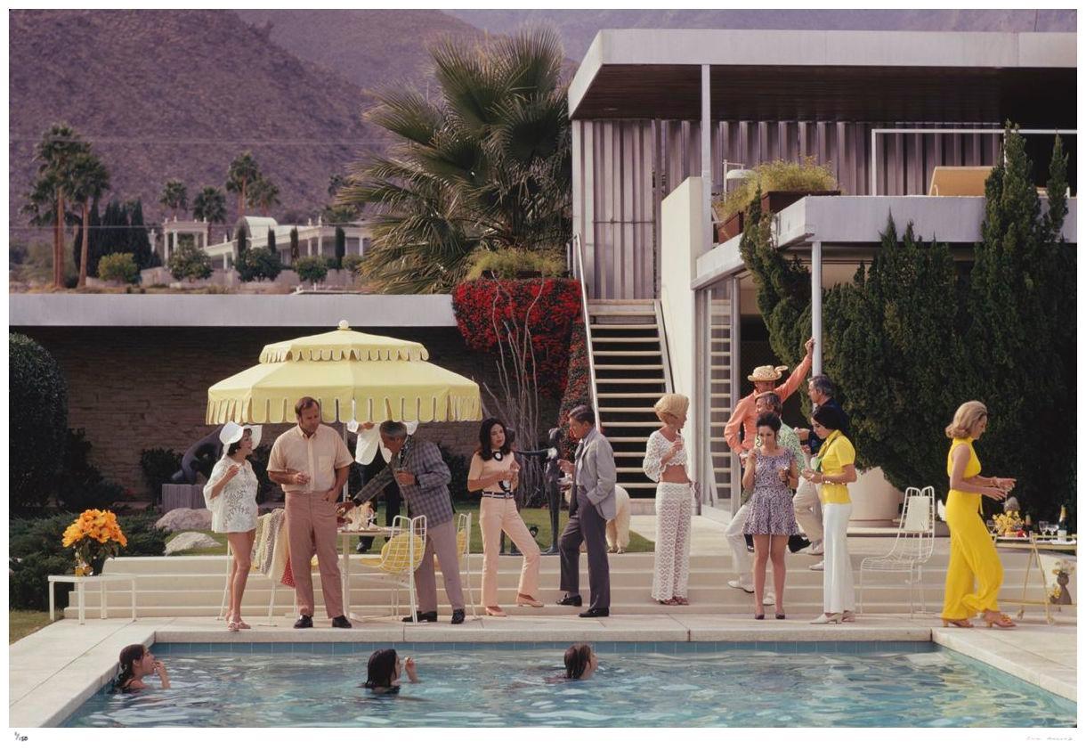 Poolside Host 1970 - Slim Aarons Estate Stamped

Guests by the pool at Nelda Linsk’s desert house in Palm Springs, California, January 1970. The house was designed by Richard Neutra for Edgar J. Kaufmann. At far left is Lita Baron. Helen Dzo Dzo is