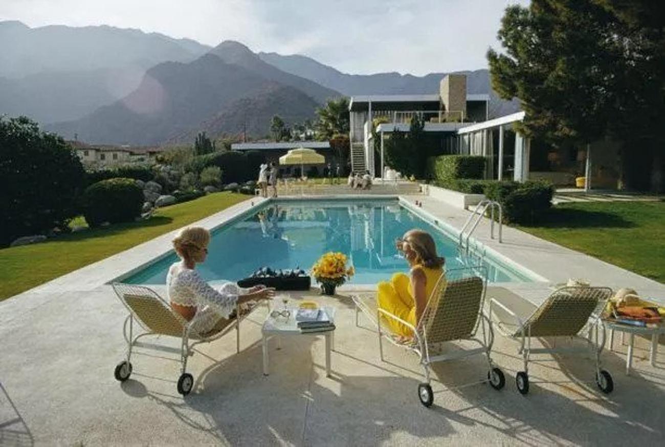 Poolside Pairs 
1970
by Slim Aarons

Slim Aarons Limited Estate Edition

Former fashion model Helen Dzo Dzo Kaptur (in white lace), Nelda Linsk (in yellow), wife of art dealer Joseph Linsk, and actress Lita Baron (in white sunhat) at the Kaufmann