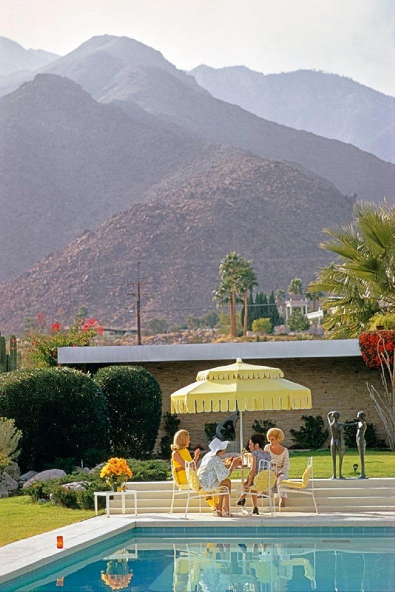 'Poolside Scenery' 1970 Slim Aarons Limited Estate Edition Print 

Nelda Linsk (left, in yellow), wife of art dealer Joseph Linsk with guests by the pool at the Linsk's desert house in Palm Springs, January 1970. At centre, left is actress Lita