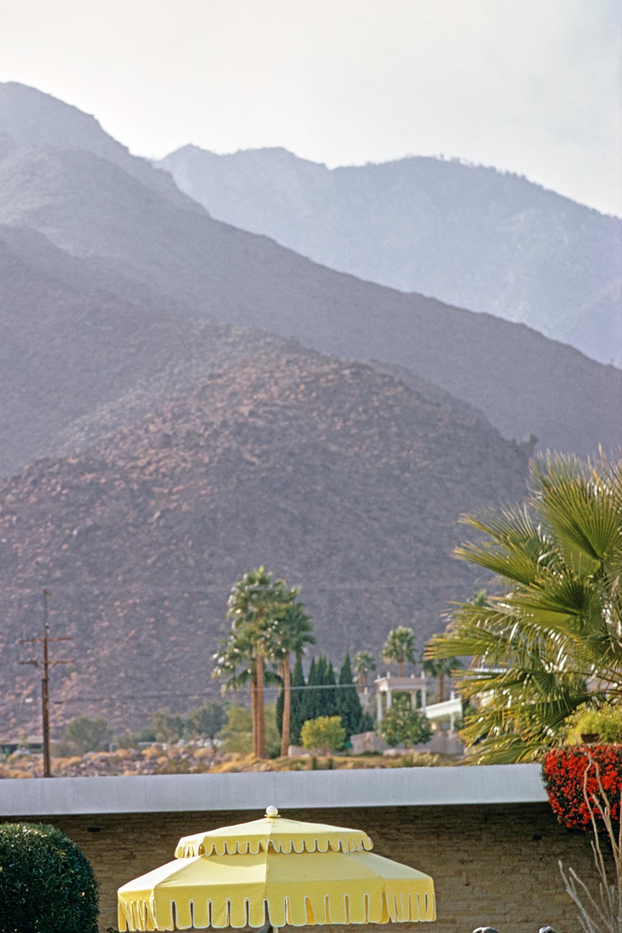 Dieses Porträtfoto von 1970, aufgenommen vom Society-Fotografen Slim Aarons, zeigt Nelda Linsk (links, in gelb), die Frau des Kunsthändlers Joseph Linsk, mit Gästen am Pool des Linsk-Hauses in Palm Springs, Januar 1970. In der Mitte links die