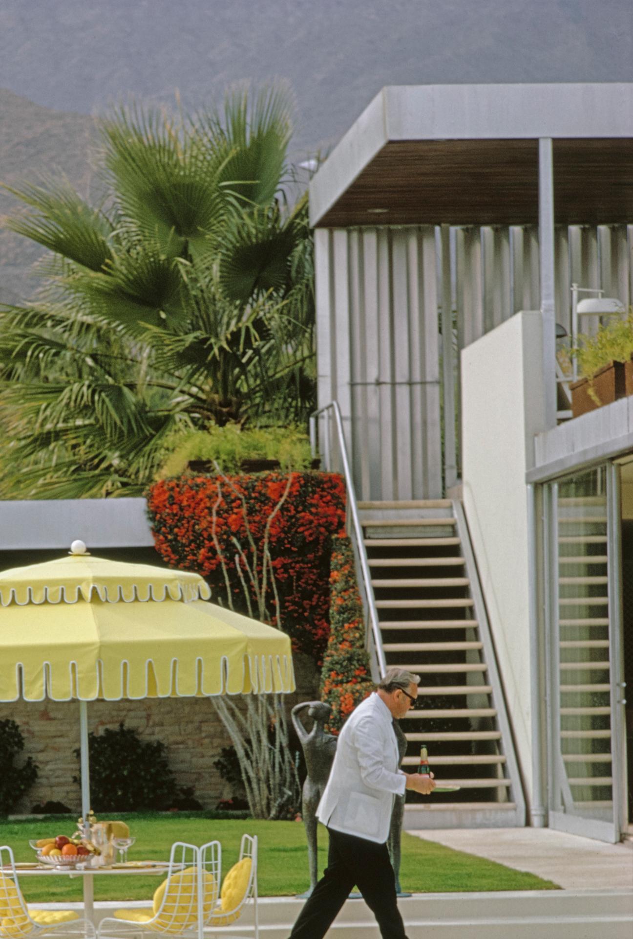 Dieses Porträtfoto aus den 1970er Jahren, aufgenommen von dem Society-Fotografen Slim Aarons, zeigt einen Kellner am Pool des Wüstenhauses von Nelda Linsk in Palm Springs, Januar 1970. Das Haus wurde von Richard Neutra für Edgar J. Kaufmann