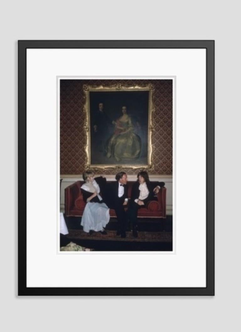 1968: From left to right; singer Marianne Faithfull, the Honorable Desmond Guinness and Mick Jagger (of the Rolling Stones) sit on a sofa under a large gilt framed painting of a woman in 18th century dress at Leixlip Castle, Ireland, the home of