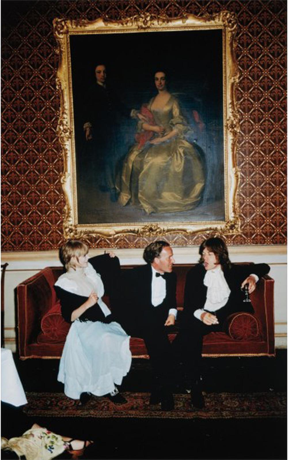 1968: From left to right; singer Marianne Faithfull, the Honorable Desmond Guinness and Mick Jagger (of the Rolling Stones) sit on a sofa under a large gilt framed painting of a woman in 18th century dress at Leixlip Castle, Ireland, the home of