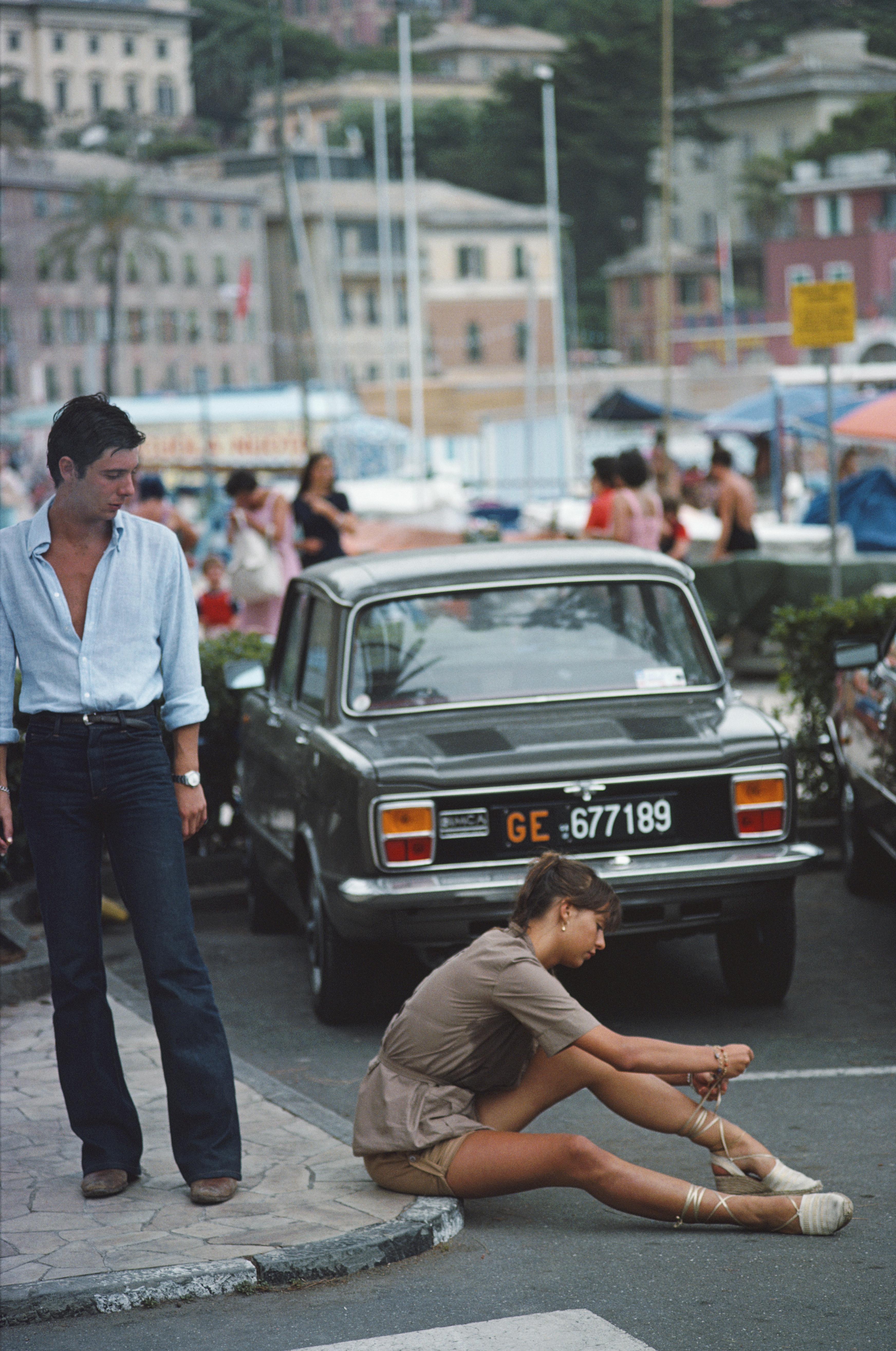 'Port Life' 1977 Slim Aarons Limited Estate Edition Print 

A man stops to watch a young woman tie her sandals on the pavement in Portofino marina, August 1977.

Produced from the original transparency
Certificate of authenticity supplied 
Archive