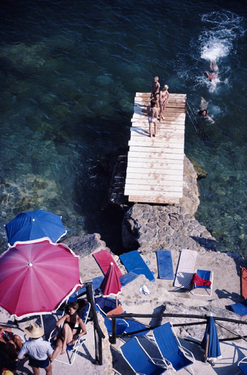Porto Ercole 
1980
von Slim Aarons

Slim Aarons Limited Estate Edition

Ein Steg ragt aus einer felsigen Küstenlinie in Porto Ercole, Toskana, August 1980.

ungerahmt
C Typ Druck
gedruckt 2023
24 x 20"  - Papierformat

Begrenzt auf 150 Abzüge -