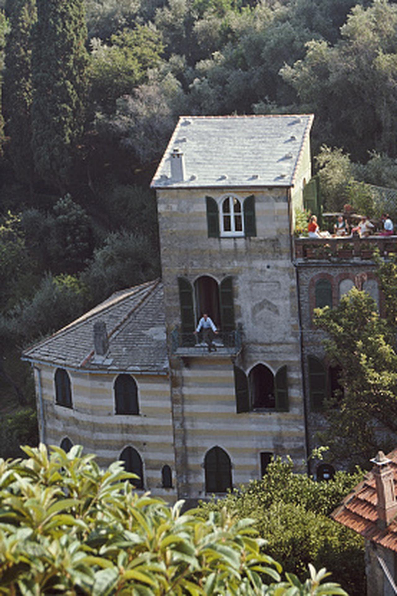 Esta fotografía de paisaje de mediados de la década de 1980, captada por el fotógrafo de sociedad Slim Aarons, muestra a unos invitados relajándose en la terraza de la villa de Umberto y Pucci Nordio, en Portofino.

Se trata de una edición sellada y