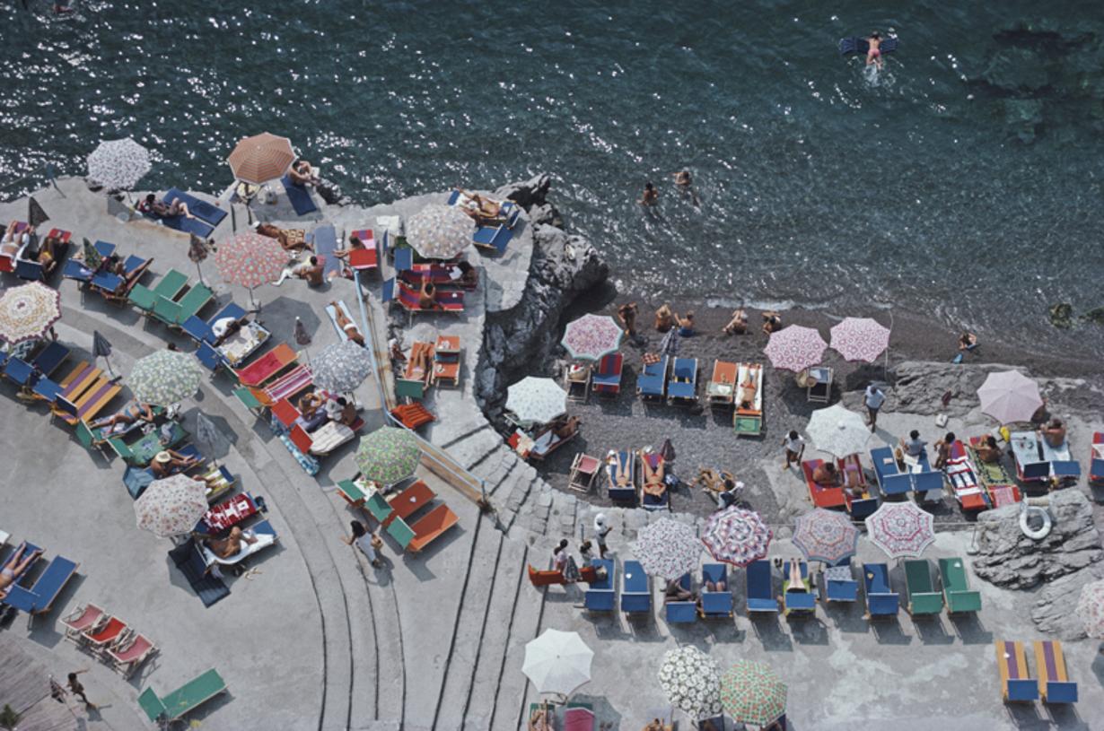 Positano Beach 
1979
by Slim Aarons

Slim Aarons Limited Estate Edition

Elevated view looking down on sunbathers and parasols on the beach at La Scogliera beach in Positano, Italy, 1979

unframed
c type print
printed 2023
16×20 inches - paper