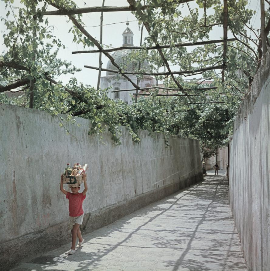 Positano 
1958
by Slim Aarons

Slim Aarons Limited Estate Edition

A little boy carries a basket of groceries home in Positano, 1958

unframed
c type print
printed 2023
16 × 16 inches - paper size


Limited to 150 prints only – regardless of paper