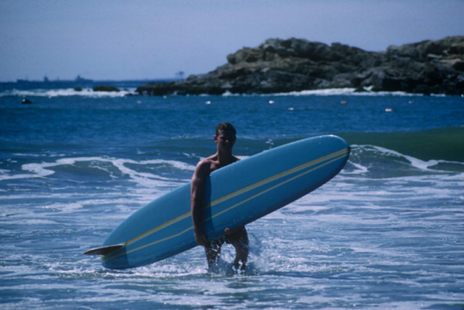 A surfer carrying his board at a Rhode Island beach, September 1965. (Photo by Slim Aarons/Getty Images)

Slim Aarons Estate Edition, Certificate of Authenticity included
Numbered and stamped by the Slim Aarons Estate

Modern estate edition with