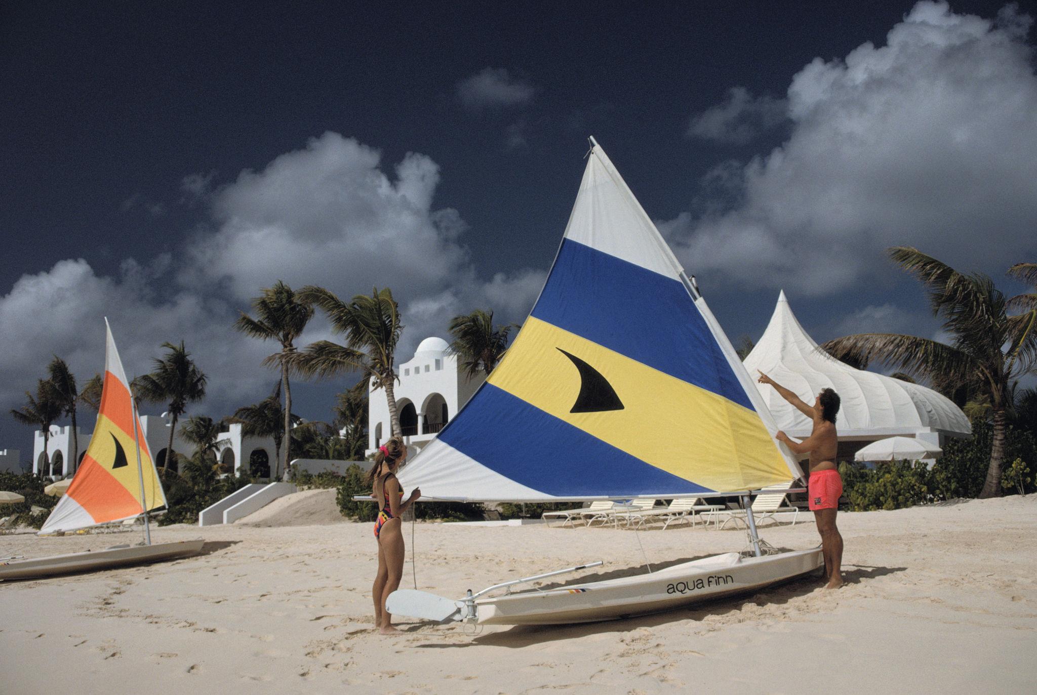 segeln in Anguilla' 1992 Slim Aarons Limitierte Nachlassausgabe Druck 

Ein Ehepaar richtet das Segel seines Beibootes in einem Luxusresort auf der Insel Anguilla in den Westindischen Inseln, Januar 1992. 

Hergestellt aus der
