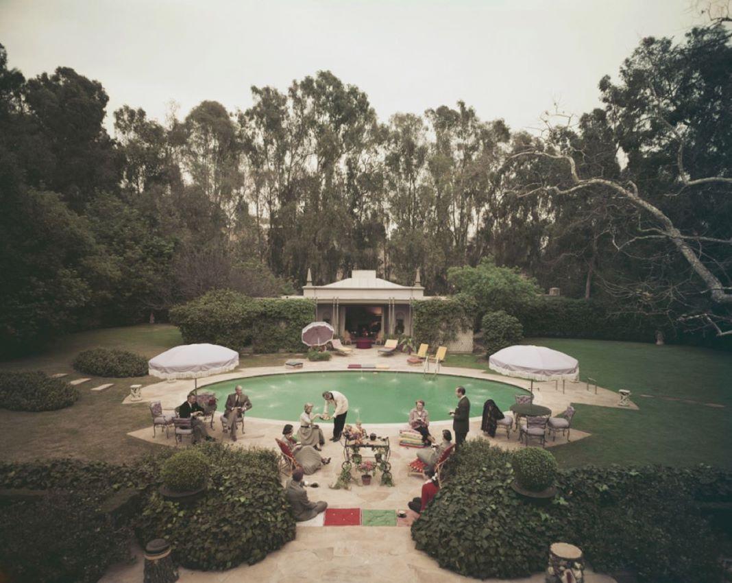 Scone Madam 

1960

Afternoon tea round the pool on a coolÂ day at the home of interior decorator James Pendleton in Beverly Hills. A Wonderful Time 

Photo by Slim Aarons

16x20” / 41 x 51 cm - paper size 
Archival pigment print
unframed 
(framing
