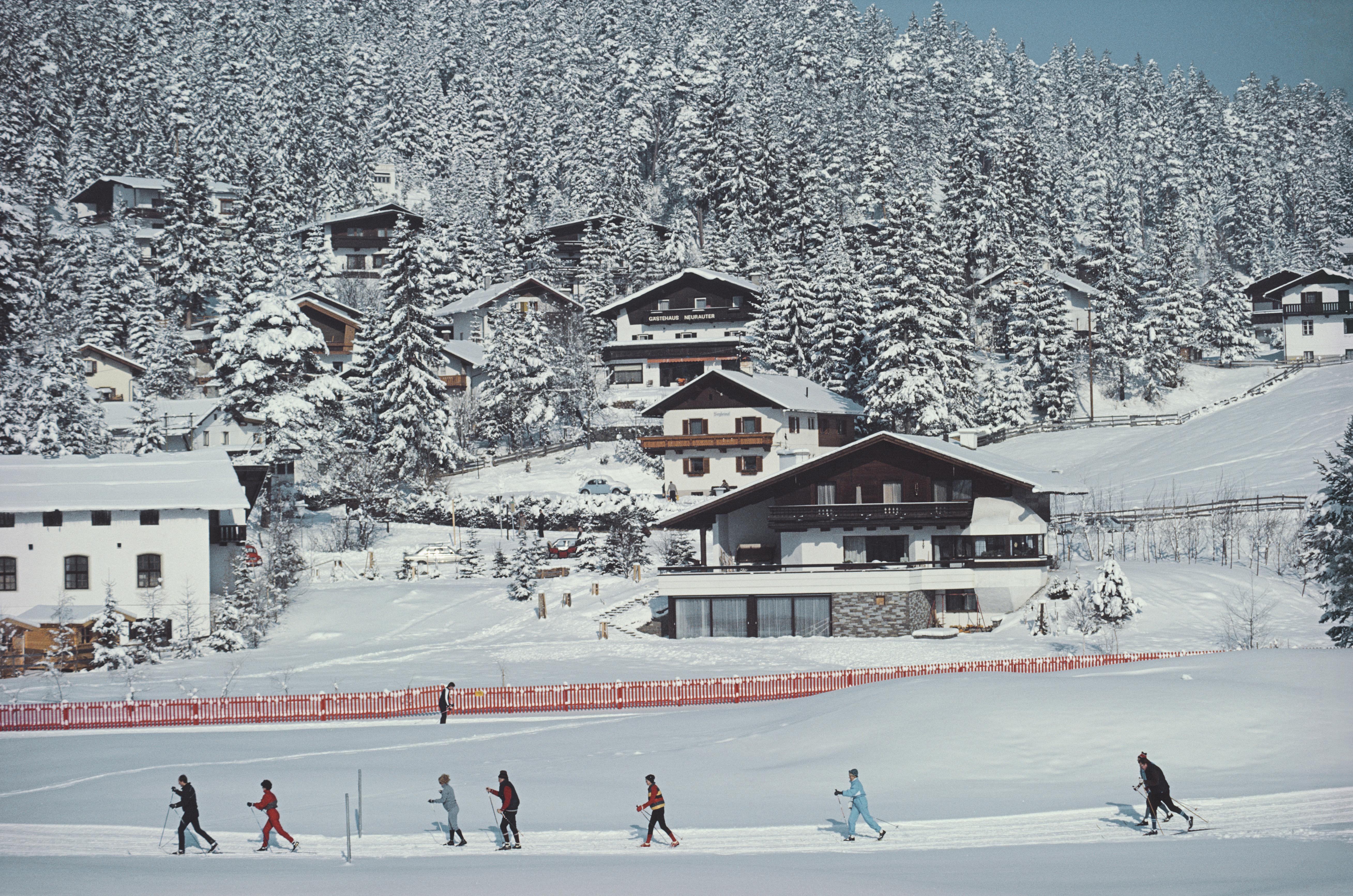This mid-1980s winter landscape photograph, captured by society photographer Slim Aarons, features a group of men and women go cross-country skiing in Seefeld, Austria, 1985.

This is an estate stamped and hand numbered edition of 150 with