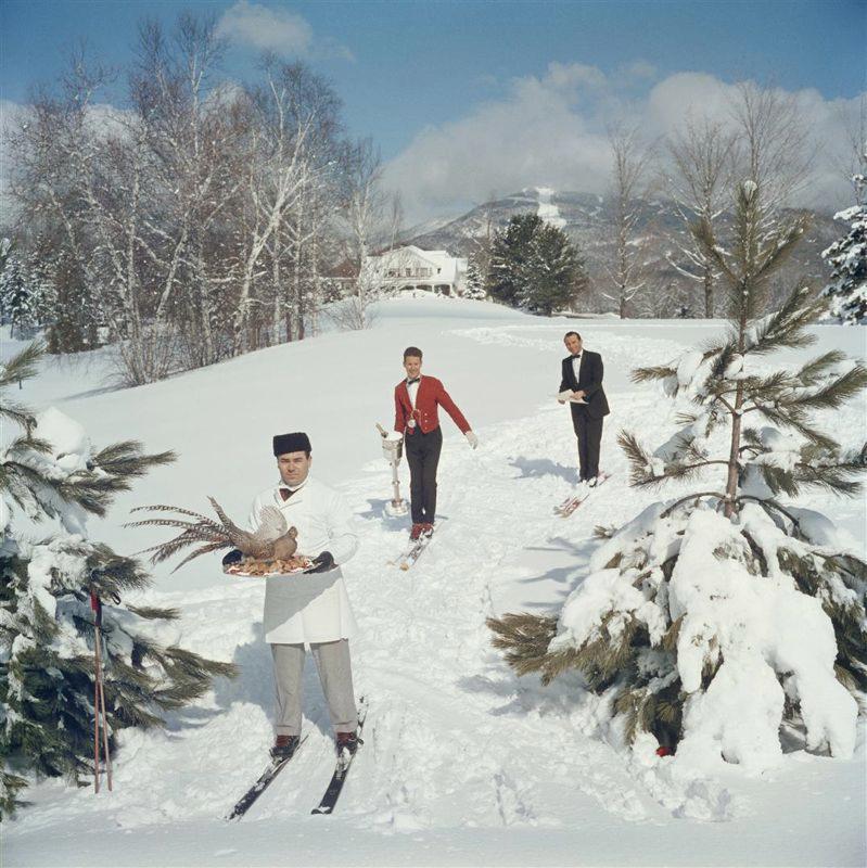 "Serveurs en ski" 1960

Slim Aarons 
Édition limitée estampillée par l'État 

Limité à 150 seulement 

Trois serveurs de ski sur une piste de ski, l'homme au premier plan portant un oiseau sur un plateau, le deuxième homme portant un vin dans un