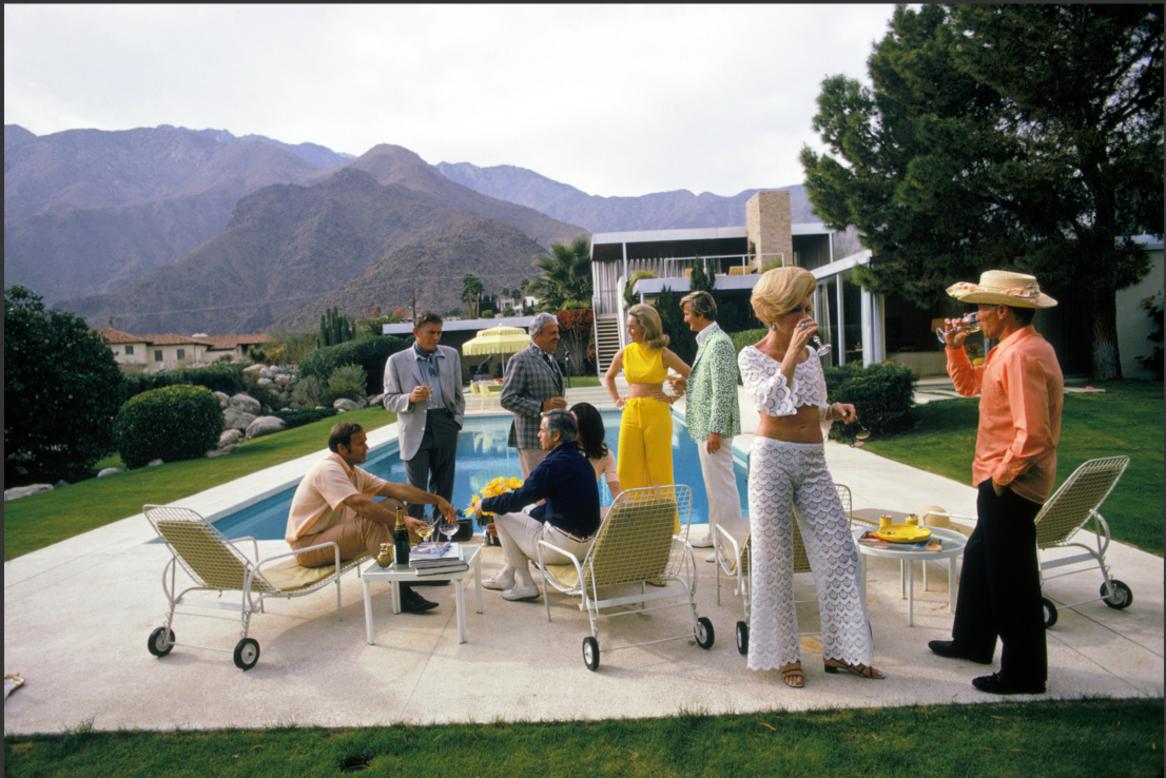 Desert House Party, 1970 by Slim Aarons, Printed Later
A poolside party at a desert house, designed by Richard Neutra for Edgar J. Kaufmann, in Palm Springs, January 1970. Featured in the group are: industrial designer Raymond Loewy (1893 - 1986,