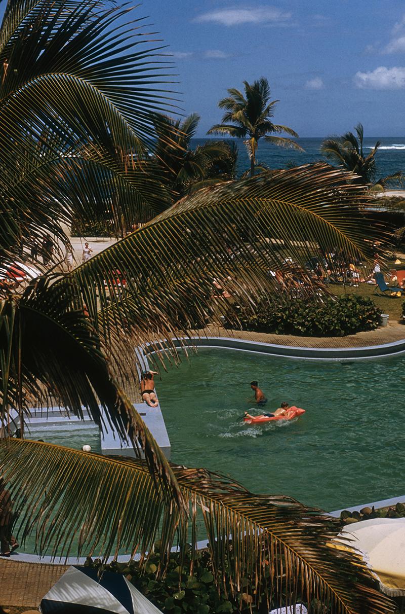 Slim Aarons Estate Stamped Edition 
Limited to 150 only 

Palm trees surrounding the swimming pool at the Caribe Hilton in San Juan, Puerto Rico, March 1956. (Photo by Slim Aarons)

This photograph epitomises the travel style and glamour of the