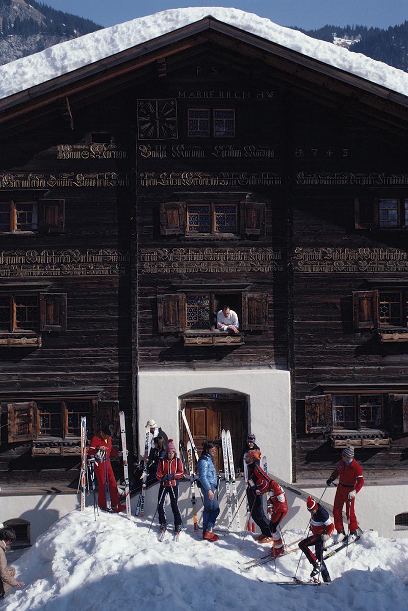 Édition estampillée par la succession de Slim Aarons 
Limité à 150 seulement 

Skieurs devant la maison Florin à Klosters, Suisse, mars 1981. (Photo par Slim Aarons)

Cette photographie incarne le style de voyage et le glamour des personnes riches