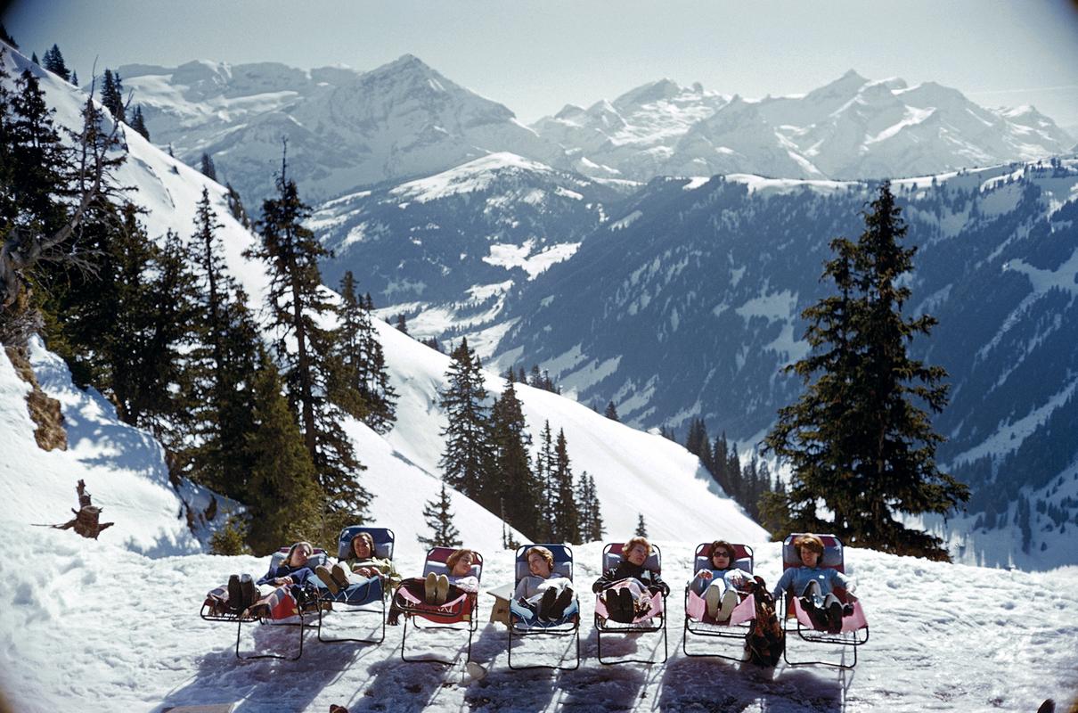 Slim Aarons - Lounging in Gstaad - Edizione con francobollo 
Limitato a 150 persone 
Villeggianti in sdraio sulle piste di Gstaad, Svizzera, marzo 1961 (Foto di Slim Aarons). 

Questa fotografia incarna lo stile di viaggio e il glamour dei ricchi e