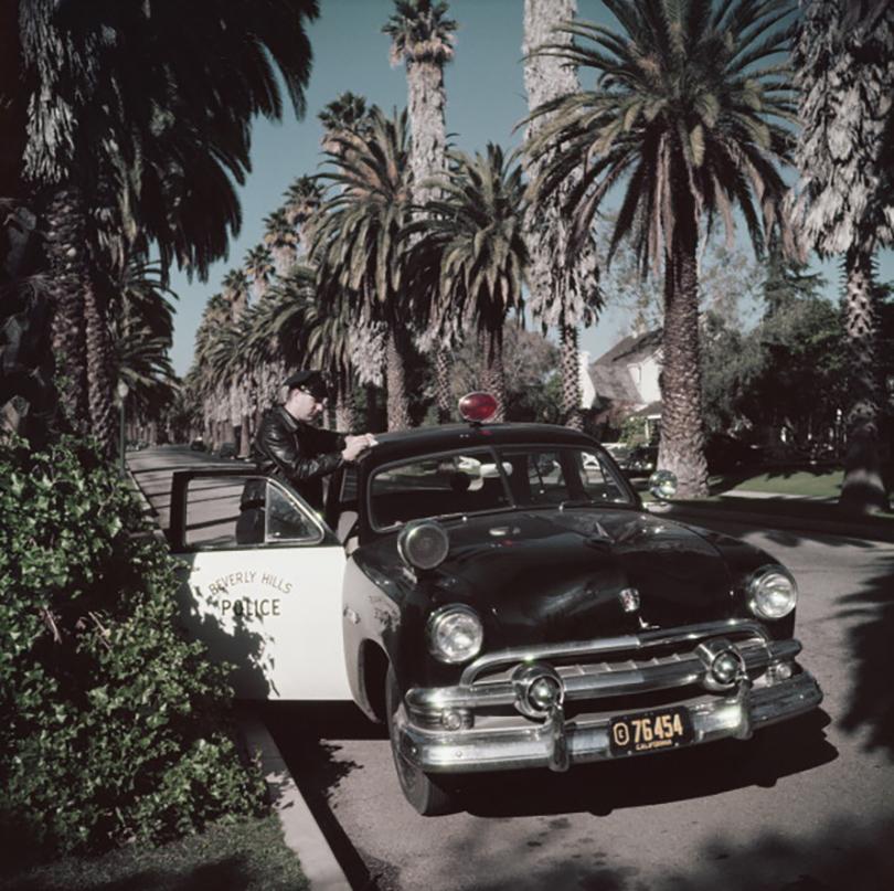 Beverly Hills police patrolman Lee R. Hathaway leaning on the roof of his car to write a report, Bedford Drive, Beverly Hills, California, 1952 

Gorgeous print measuring 40 x 40" inches / ca 102 x 102 cm’s paper size. 
 
Estate Stamped Collection