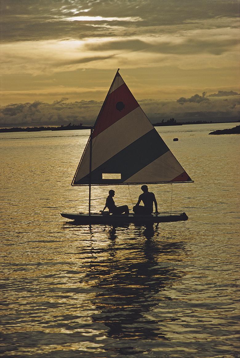 Slim Aarons Estate Stamped Edition 
Limited to 150 only 

Two people using a small sailboat in Bermuda, June 1967. (Photo by Slim Aarons)

This photograph epitomises the travel style and glamour of the period's wealthy and famous, beautifully