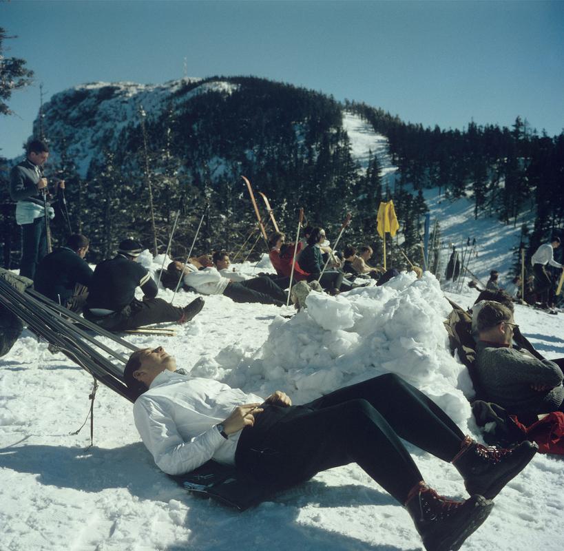 Skiers relaxing on the slopes of the Sugarbush Mountain ski resort in Warren, Vermont, USA, circa 1960. The Sugarbush resort is one of the largest ski resorts in New England. 

Gorgeous print measuring a large 30 x 30