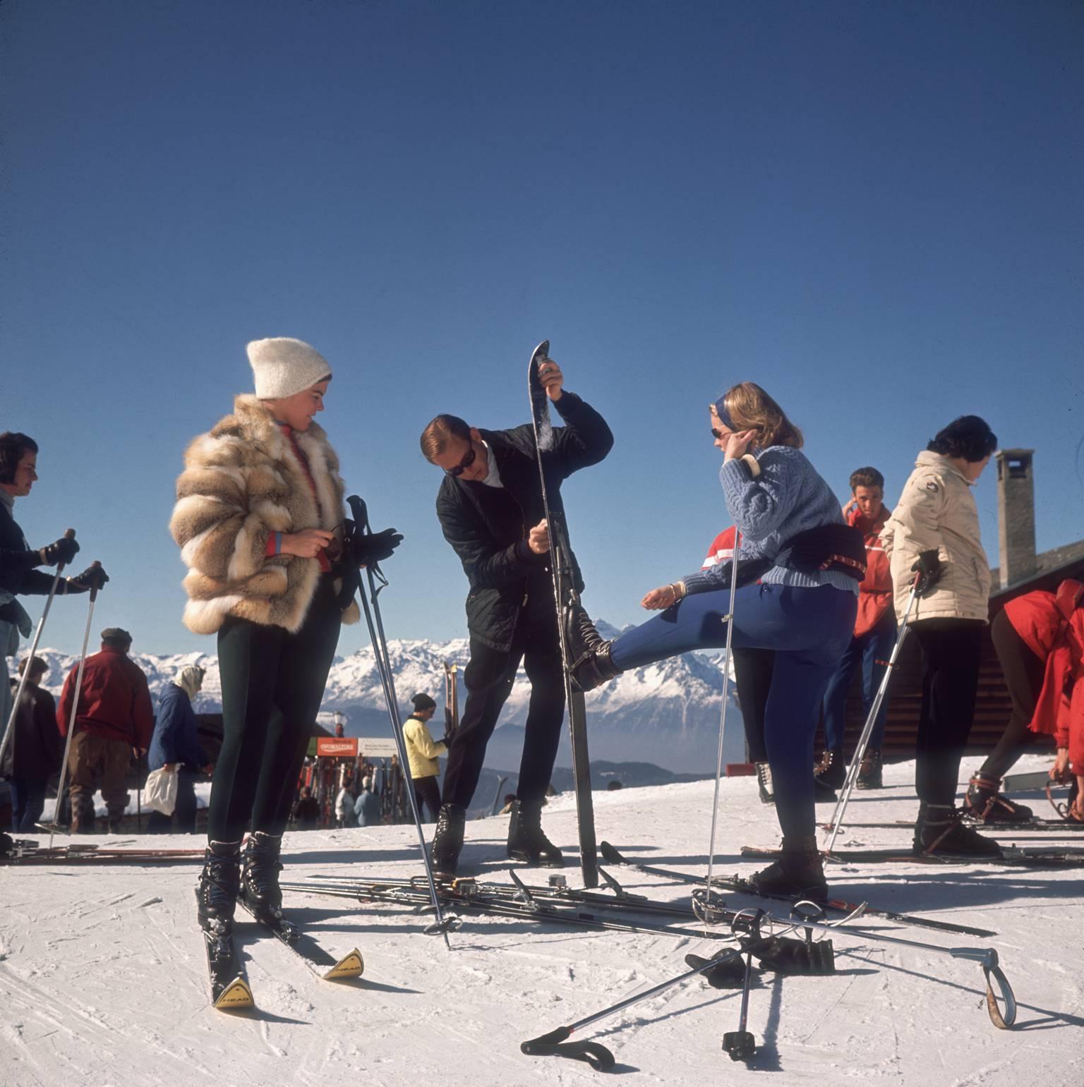 Verbier-Skifahrer" von Slim Aarons

Skifahrer in Verbier, 1964. 

Elegante Skifahrer in modischer Skikleidung, darunter eine junge Frau mit Pelzjacke, stellen die Skier ein und bereiten sich auf einen Tag auf den schönen Pisten vor, vor dem