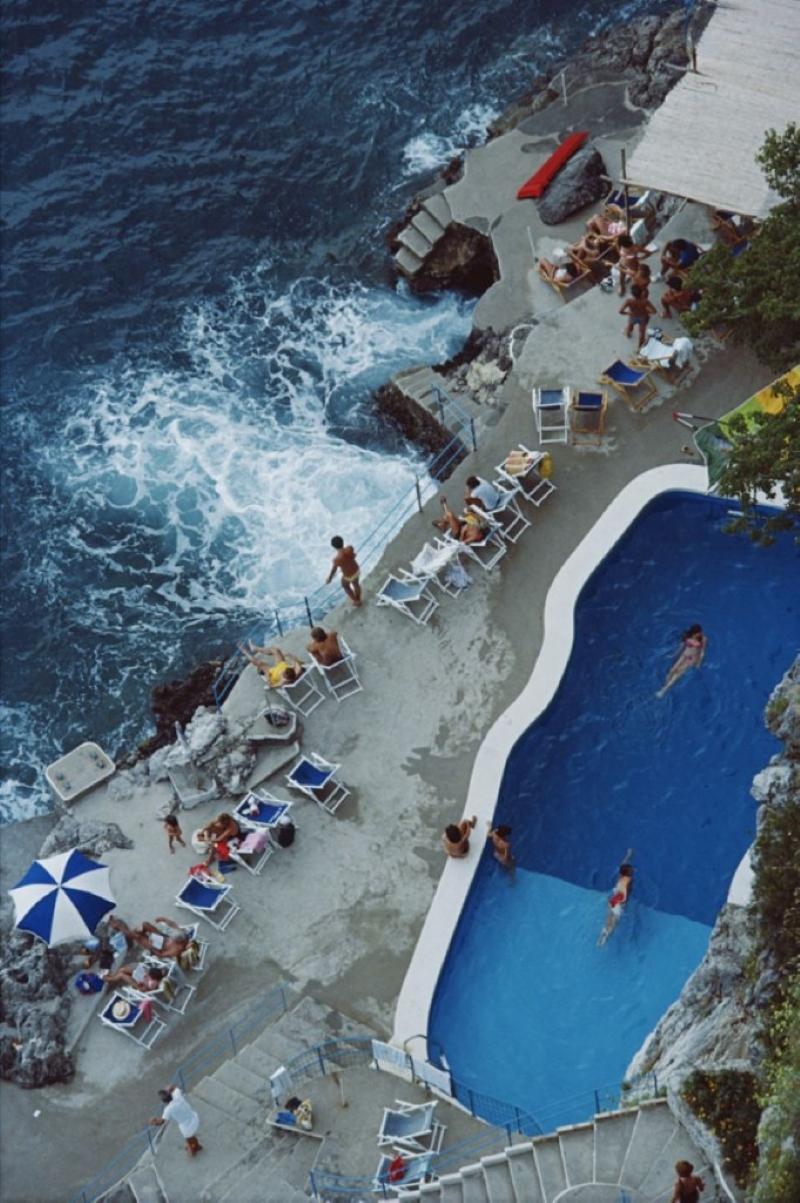 Pool an der Amalfiküste

Blick auf den Pool am Meer im Hotel St. Caterina, Amalfi, Italien, September 1984.

Slim Aarons Chromogenic C Druck 
Später gedruckt 
Slim Aarons Estate Edition 
Hergestellt unter Verwendung des einzigen Originaldias oder