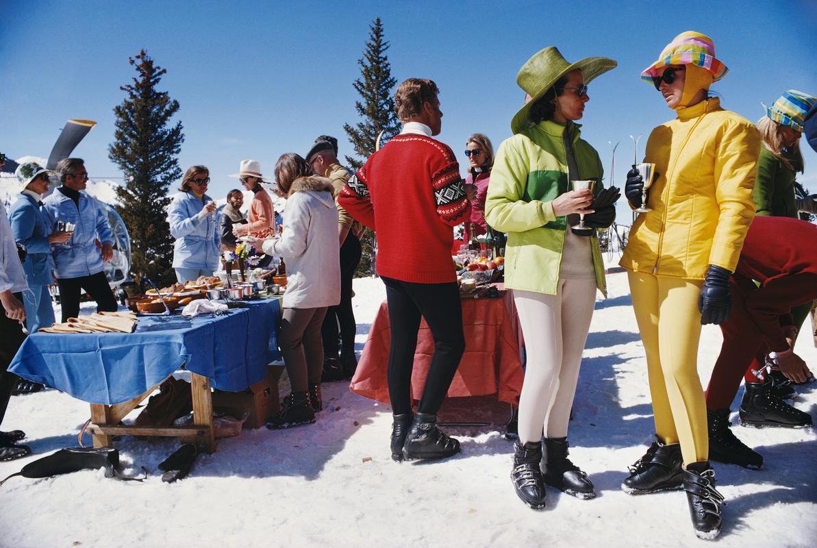 Raduno di Snowmass

Due donne, che indossano abiti da sci dai colori vivaci, sono in primo piano rispetto a un gruppo di persone che partecipano a una festa a Snowmass Village, nella contea di Pitkin, in Colorado, nell'aprile del 1968.

Formato