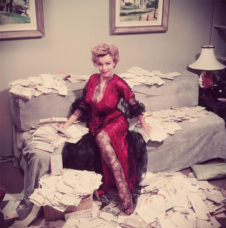 Marilyn Monroe (1926 - 1962), die ein rotes Negligé mit schwarzer Spitze trägt, sortiert kurz nach der Veröffentlichung ihres Films "Der Asphaltdschungel" ihre Fanpost. 

Nachlassgestempelte und handnummerierte Auflage von 150 Stück mit