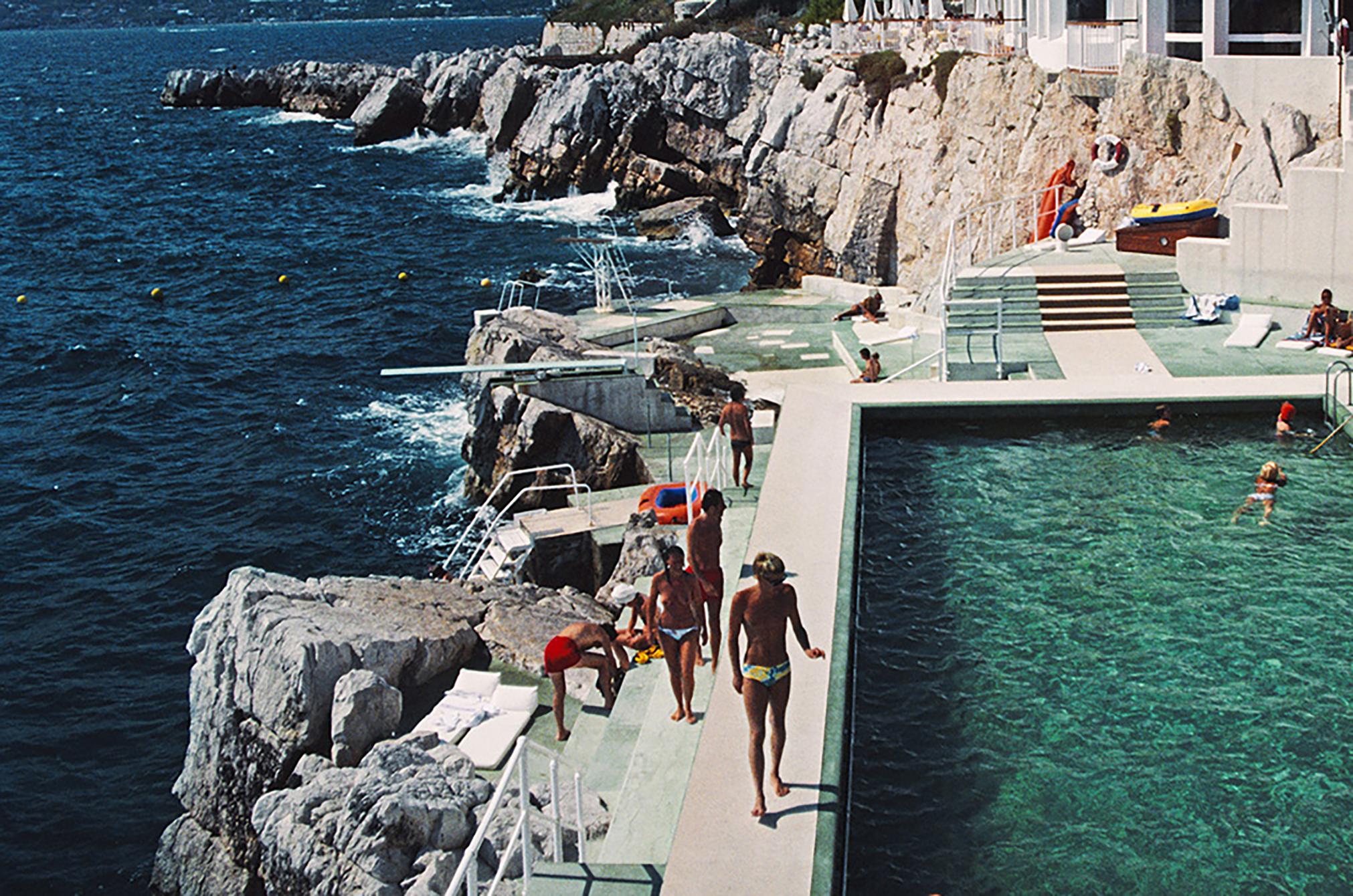 Photographie de l'édition de l'Hôtel du Cap Eden-Roc : Poolside in Antibes - Bleu Nude Photograph par Slim Aarons