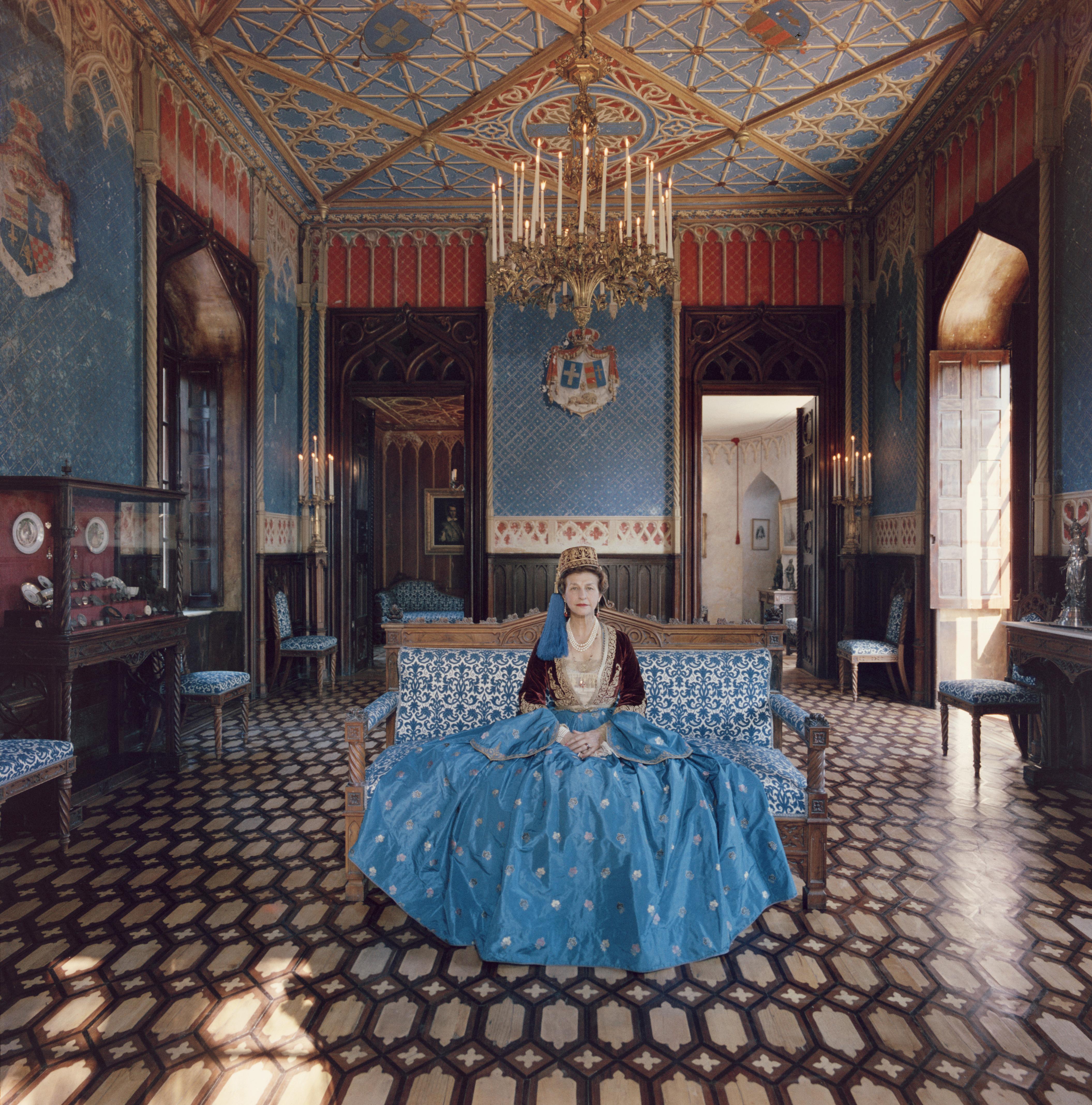 'Jean Serpieri' 1961 Slim Aarons Limited Edition Estate Stamped Print
Madame Jean Serpieri sits in the ballroom of the Tour La Reine near Athens, wearing a gown that belonged to the wife of Otto, the first king of modern Greece, December 1961. The