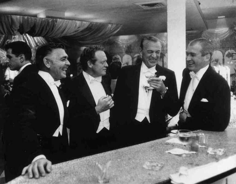 Film stars (left to right) Clark Gable (1901 - 1960), Van Heflin (1910 - 1971), Gary Cooper (1901 - 1961) and James Stewart (1908 - 1997) enjoy a joke at a New Year's party held at Romanoff's in Beverly Hills. Celebrity photography.

Estate stamped