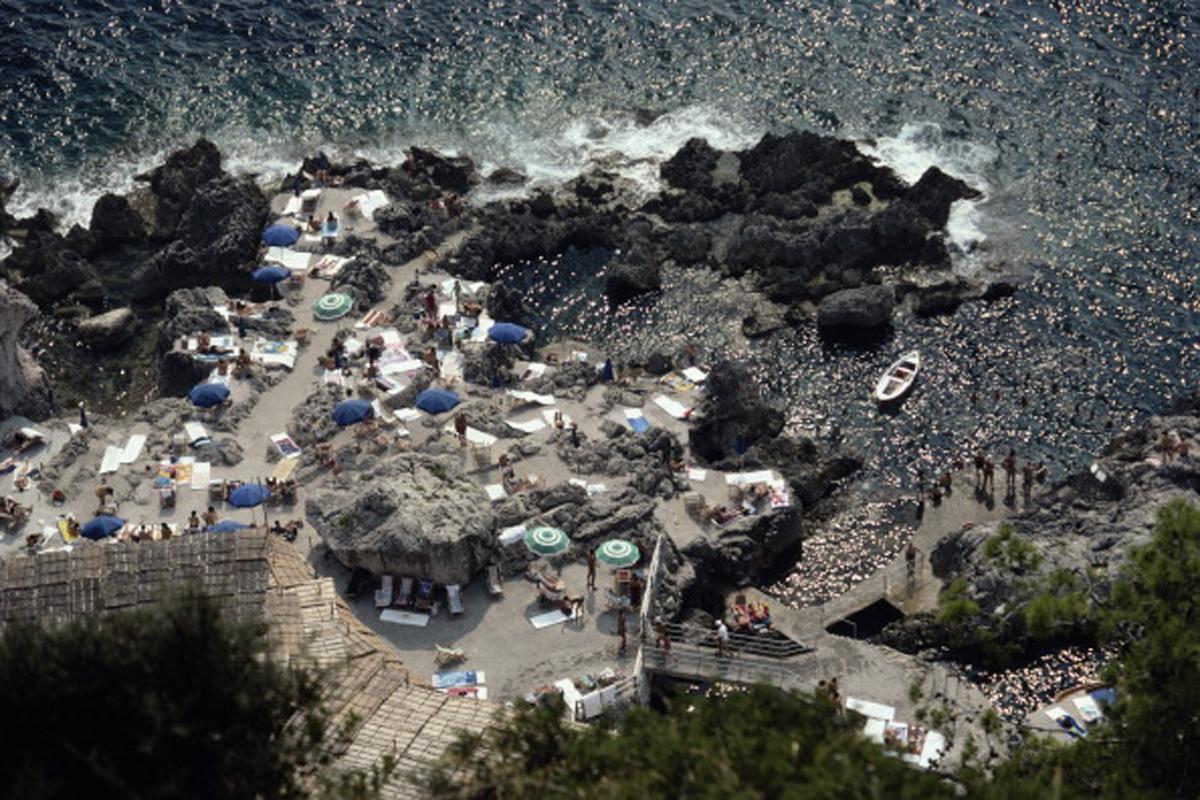 Il Canille
1978 (printed later)
C print
Estate stamped and numbered edition 1 of 150 
with Certificate of authenticity

Caption: Sunbathers lounge on the white-painted terrace of Il Canille, built into the rocks of Pizzolungo overlooking the waters