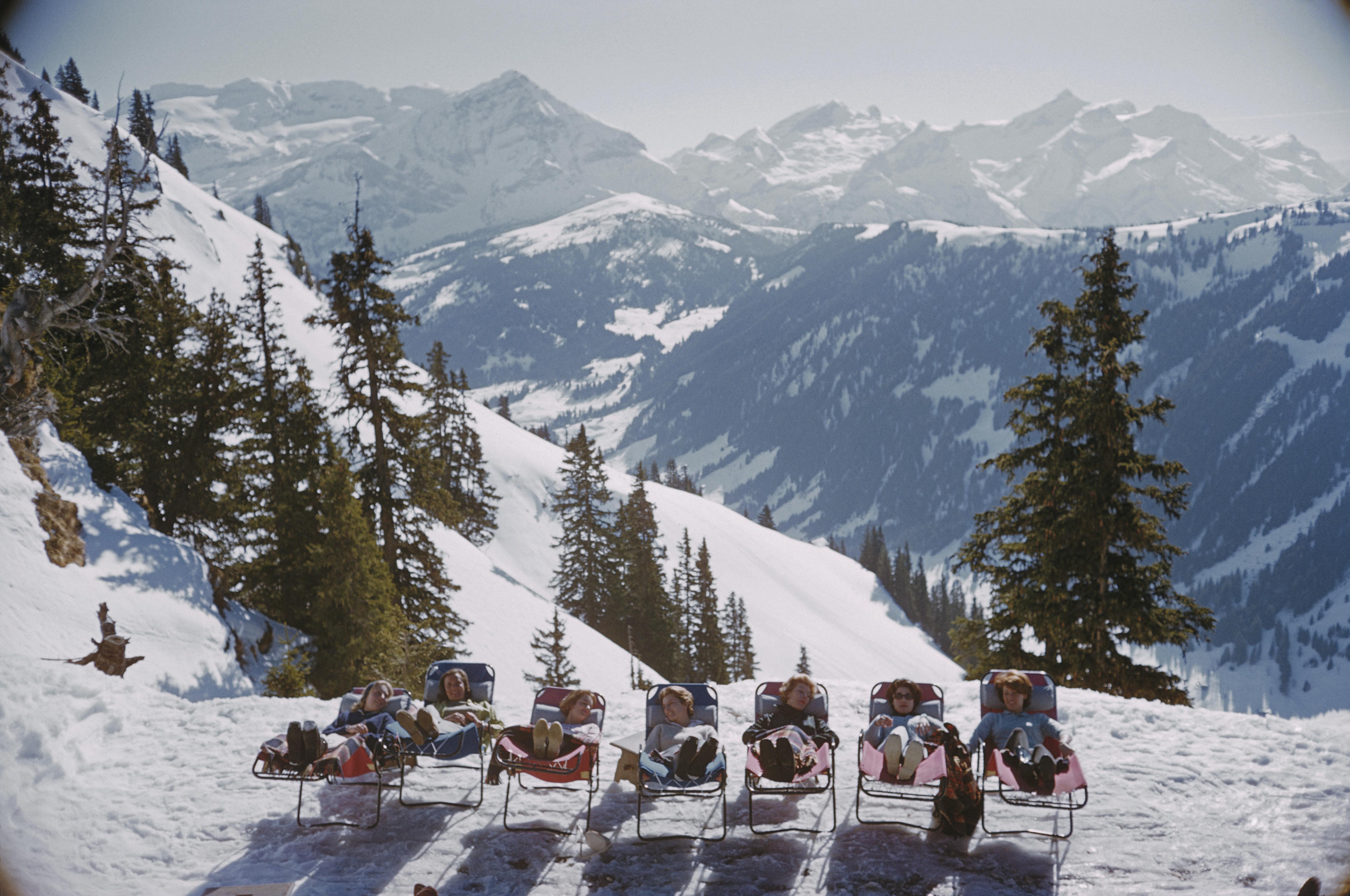 Holidaymakers in sun loungers on the slopes at at Gstaad, Switzerland, March 1961. 

Slim Aarons
Lounging in Gstaad
Chromogenic Lambda print
Printed Later
Slim Aarons Estate Edition
Complimentary dealer shipping to your framer, worldwide.
Stamped