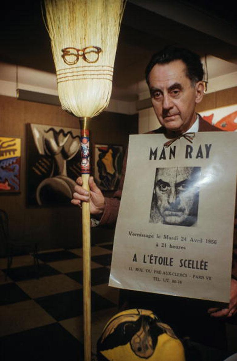 Man Ray in Paris
1956
Chromogenic Lambda Print
Estate edition of 150

American surrealist artist and photographer Man Ray (1890 - 1976) with some examples of his work at his Left Bank studio in Paris, April 1956. (Photo by Slim Aarons/Hulton