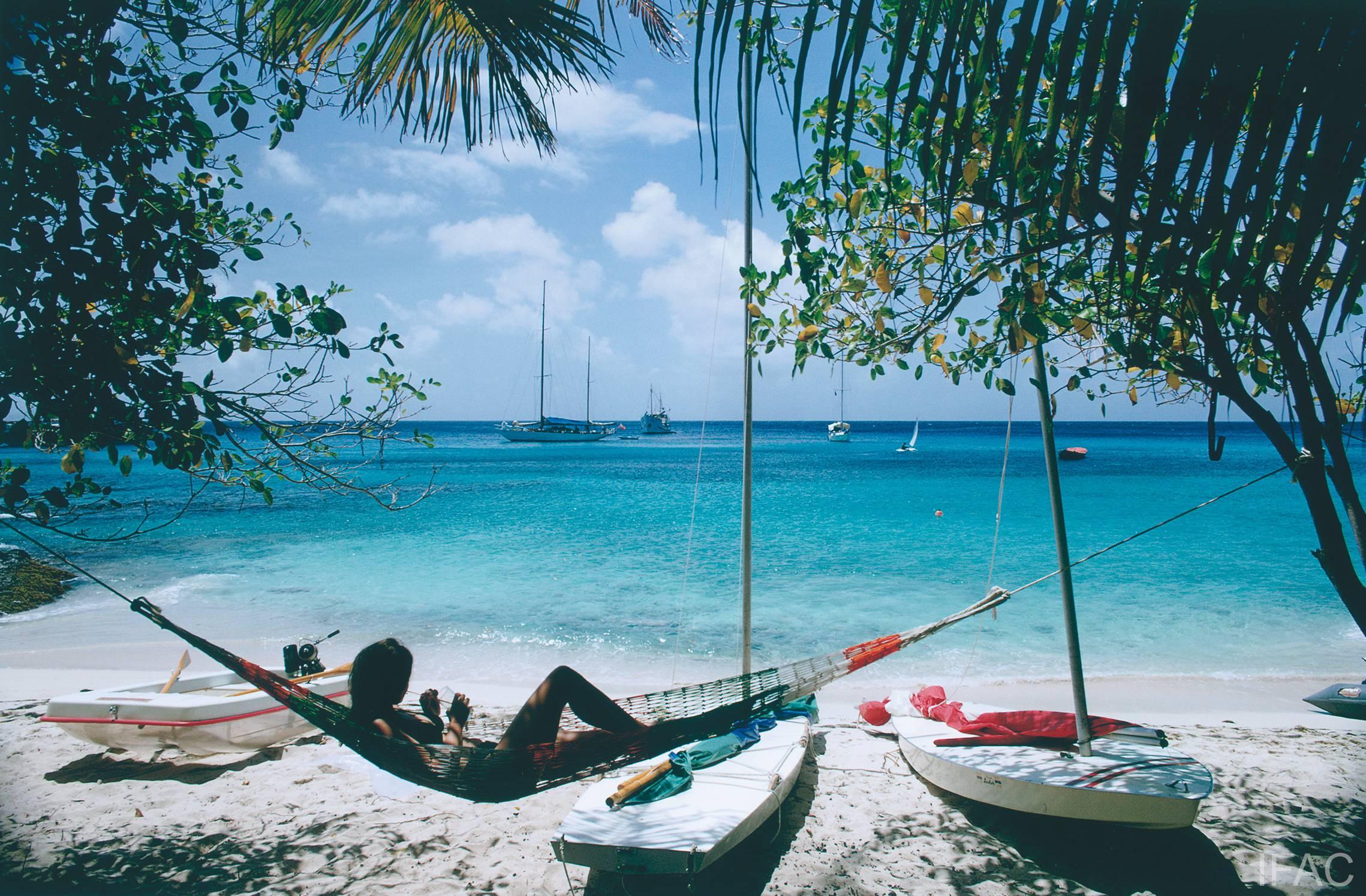Marzo 1973: Linda Ashland si rilassa su un'amaca da spiaggia sull'isola di Mustique, nelle Grenadine. 

Edizione stampata e numerata a mano di 150 esemplari con certificato di autenticità dell'azienda. 

Slim Aarons (1916-2006) ha lavorato