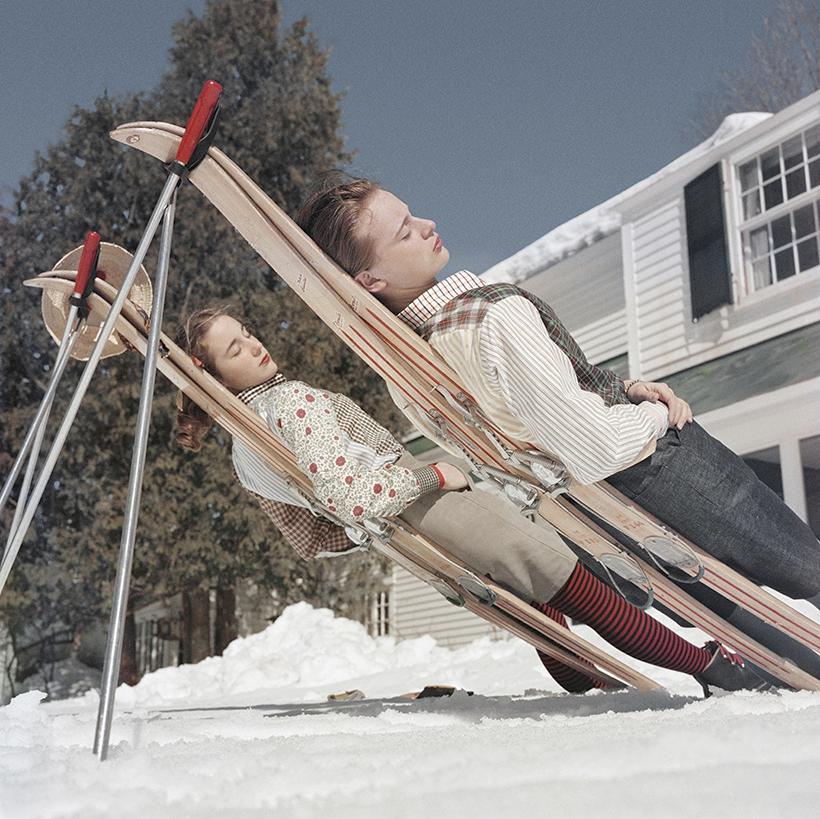 Slim Aarons 'Skifahren in Neuengland' 
Zwei Frauen liegen auf improvisierten Sonnenliegen in Cranmore Mountain, New Hampshire, um 1955 (Foto von Slim Aarons, später gedruckt)
Dieses Foto verkörpert den Reisestil und den Glamour der Reichen und