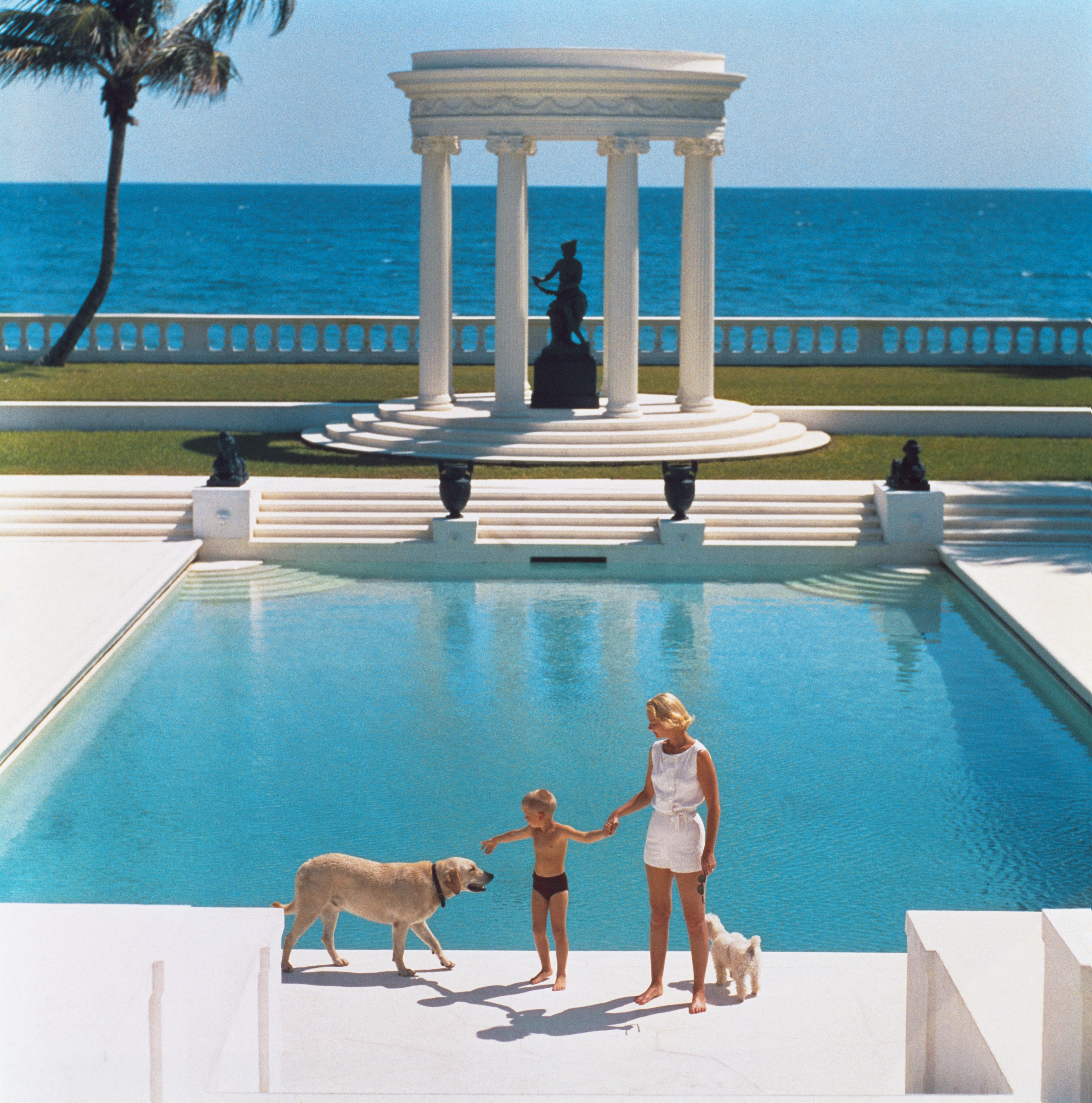 'Nice Pool' 1955 Slim Aarons Limited Edition Estate Stamped Print
1955. American writer C.Z. Guest (Mrs. F.C. Winston Guest, 1920 – 2003) and her son Alexander Michael Douglas Dudley Guest in front of their Grecian temple pool on the ocean-front