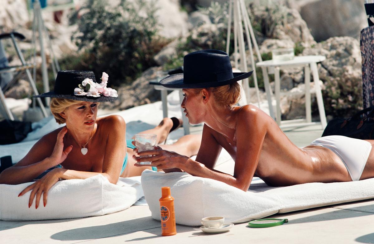 Slim Aarons Estate Print - Sunbathing In Antibes

Dani Geneux (left) and Marie-Eugenie Gaudfrin sunbathing at the Hotel du Cap Eden-Roc, Antibes, France, August 1976.

Photo by Slim Aarons

Slim Aarons Chromogenic C print 
Printed Later 
Slim Aarons