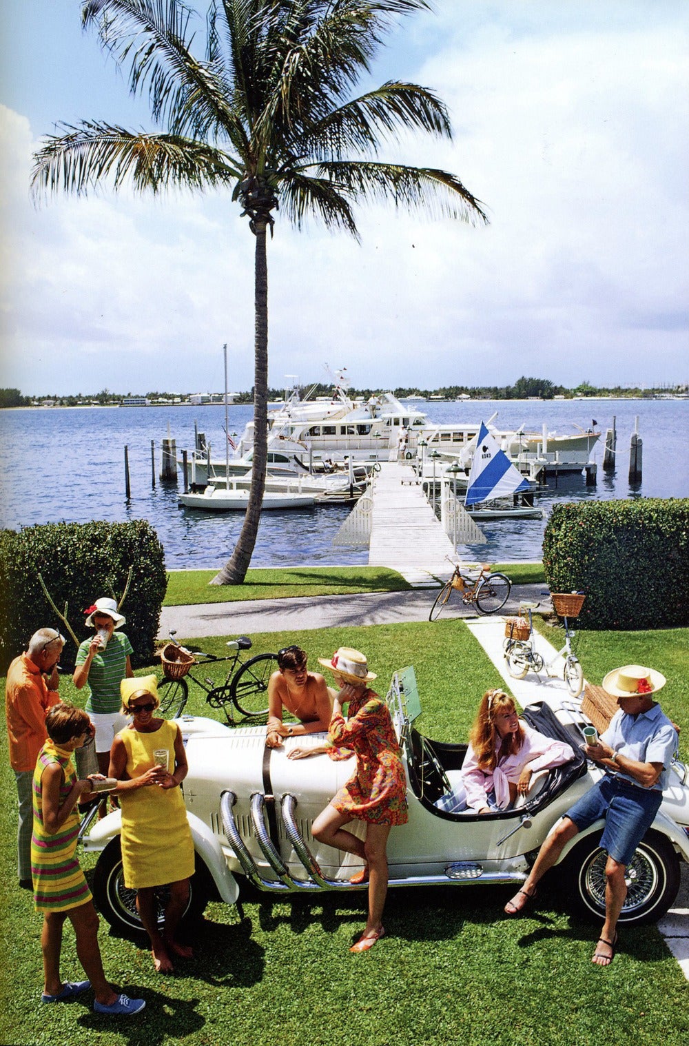 Jim Kimberly, sa femme (à l'extrême gauche) et ses amis avec sa voiture de sport blanche et ses bateaux blancs amarrés au lac Worth. Une mondaine de Palm Beach, Kimberly est consul honoraire de Jordanie. Avril 1968.  (Slim Aarons / Getty