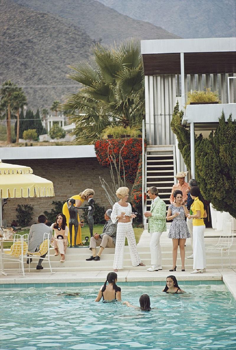 'Party on the Steps' 1970 Slim Aarons Limited Estate Edition Print 
Guests by the pool at Nelda Linsk's desert house in Palm Springs, California, January 1970. The house was designed by Richard Neutra for Edgar J. Kaufmann. Helen Dzo Dzo is seen in