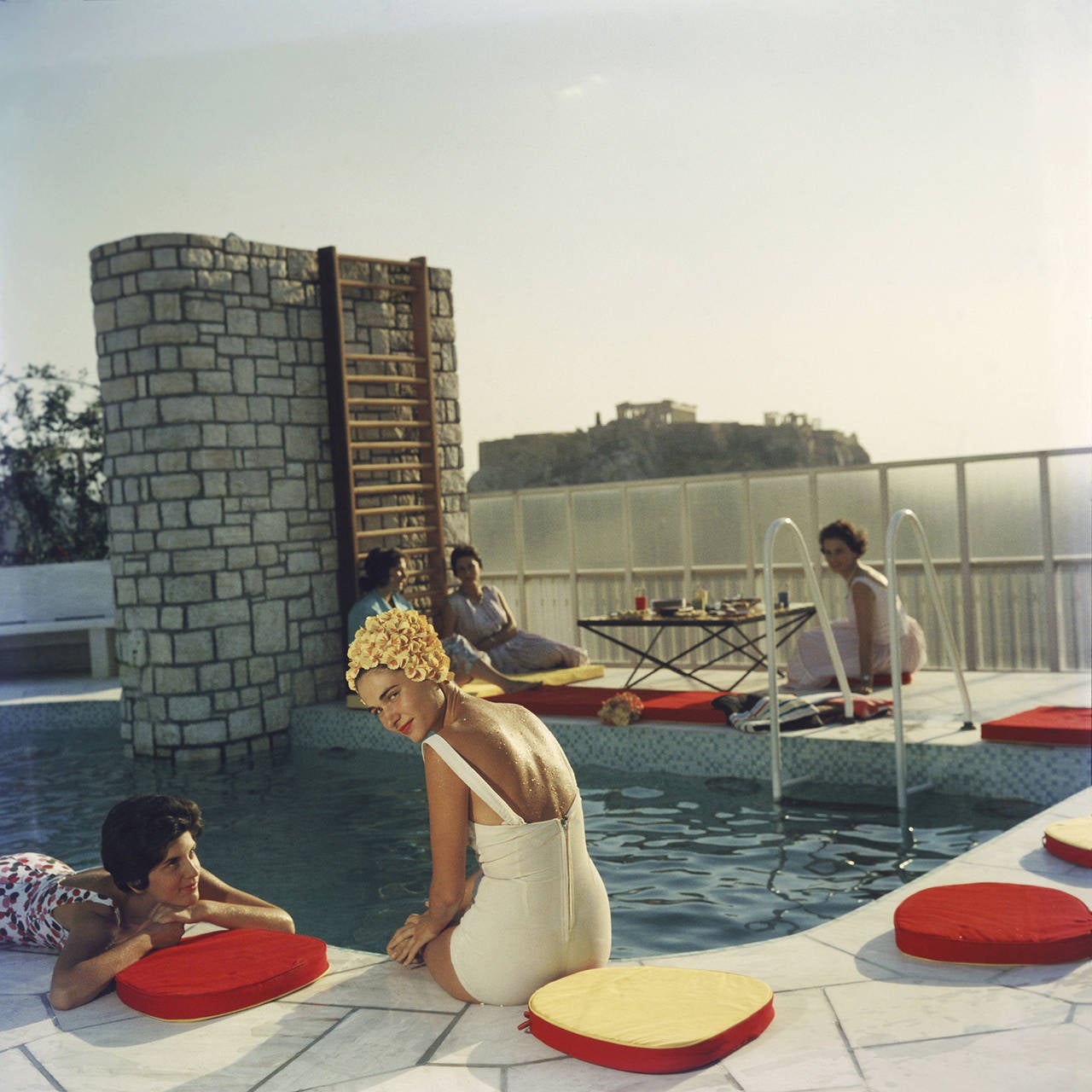 Young women by the Canellopoulos penthouse pool, Athens, July 1961. 
The Acropolis is in the background.

Slim Aarons (1916-2006) worked mainly for society publications photographing "attractive people doing attractive things in attractive places."