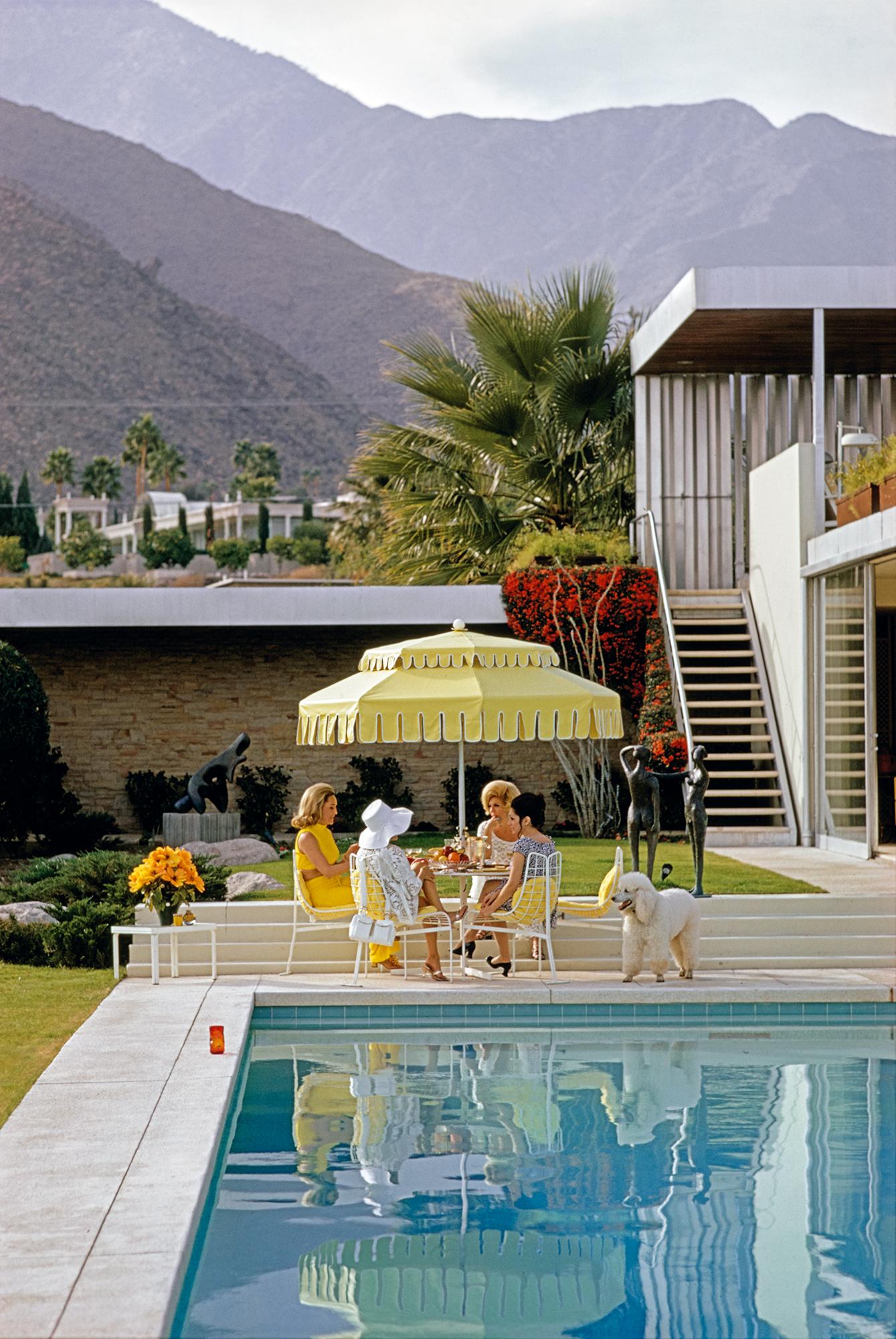 Slim Aarons
Poolside Friendship
1970 (printed later)
C print 
Estate stamped and numbered edition of 150 
with Certificate of authenticity

Nelda Linsk (left, in yellow), wife of art dealer Joseph Linsk with guests by the pool at the Linsk's desert