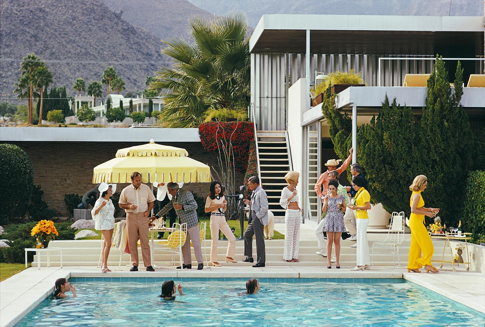 Anfitrión junto a la piscina
1970 (impreso posteriormente)
Impresión C
Edición sellada y numerada de 150 ejemplares 
con Certificado de autenticidad

Pie de foto: Invitados junto a la piscina de la casa desierta de Nelda Linsk en Palm Springs,