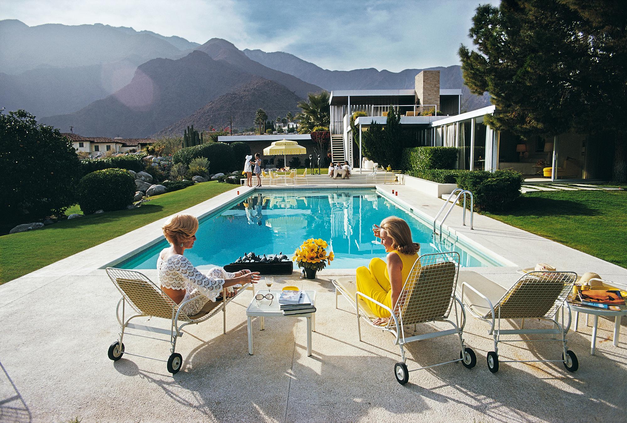 Former fashion model Helen Dzo Dzo Kaptur (in white lace) and Nelda Linsk (in yellow), wife of art dealer Joseph Linsk, at the Kaufmann Desert House in Palm Springs, California, January 1970. The Linsks are the current owners of the house.