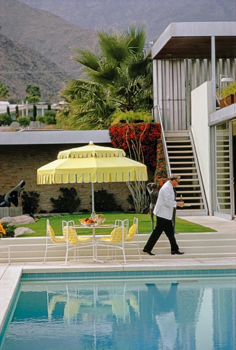 'Poolside Waiting' 1970 Slim Aarons Limited Estate Edition Print 
A waiter by the pool at Nelda Linsk's desert house in Palm Springs, January 1970. The house was designed by Richard Neutra for Edgar J. Kaufmann. 

Slim Aarons Chromogenic C print