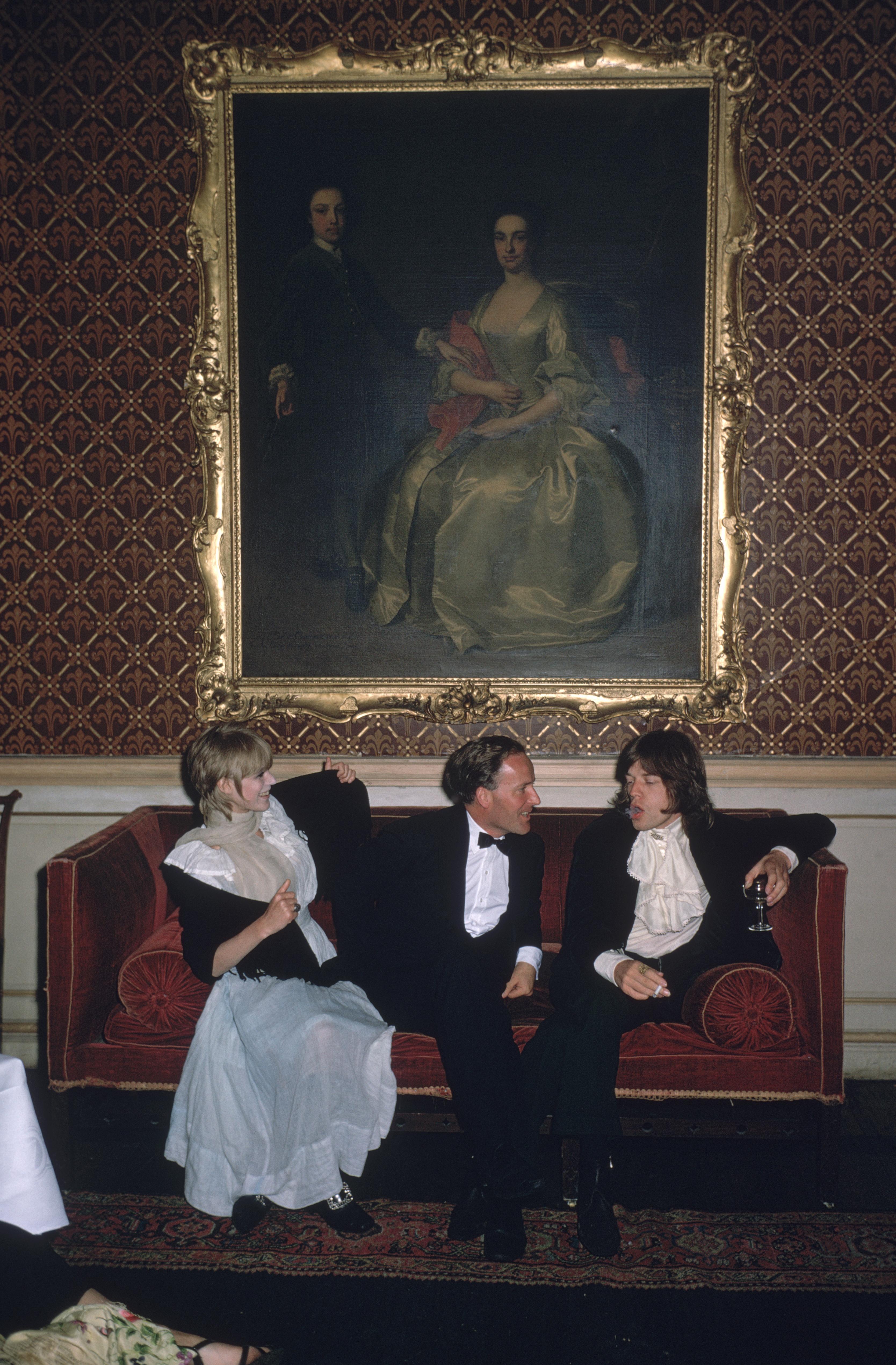 Pop und Gesellschaft" 1968 Slim Aarons Limited Estate Edition
1968: Von links nach rechts: Die Sängerin Marianne Faithfull, der ehrenwerte Desmond Guinness und Mick Jagger (von den Rolling Stones) sitzen auf einem Sofa unter einem großen