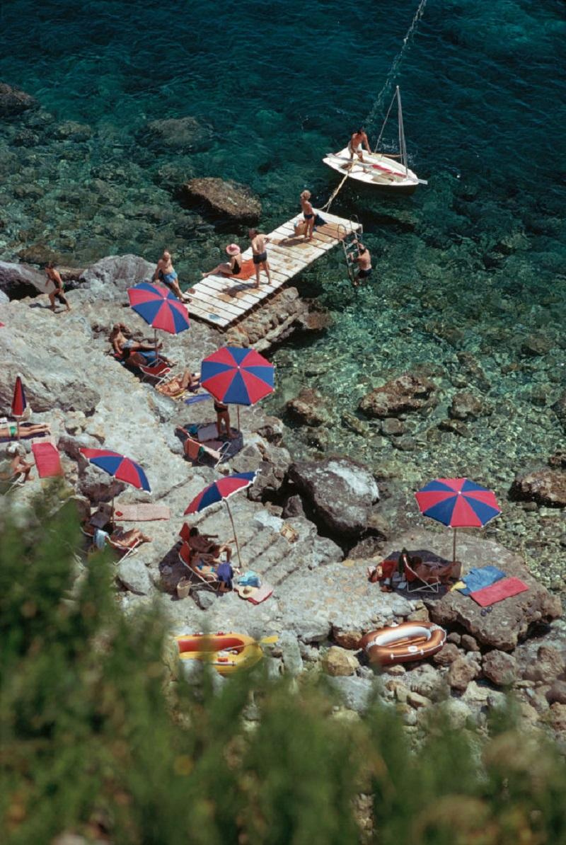 'Porto Ercole' 1973 Slim Aarons Limited Estate Edition Print 
A jetty juts out from the rocky shoreline at the Hotel Il Pellicano in Porto Ercole, Tuscany, August 1973.

Paper size 40 x 30 inches / 101 x 76 cm 
Printed in 2024 - produced from the