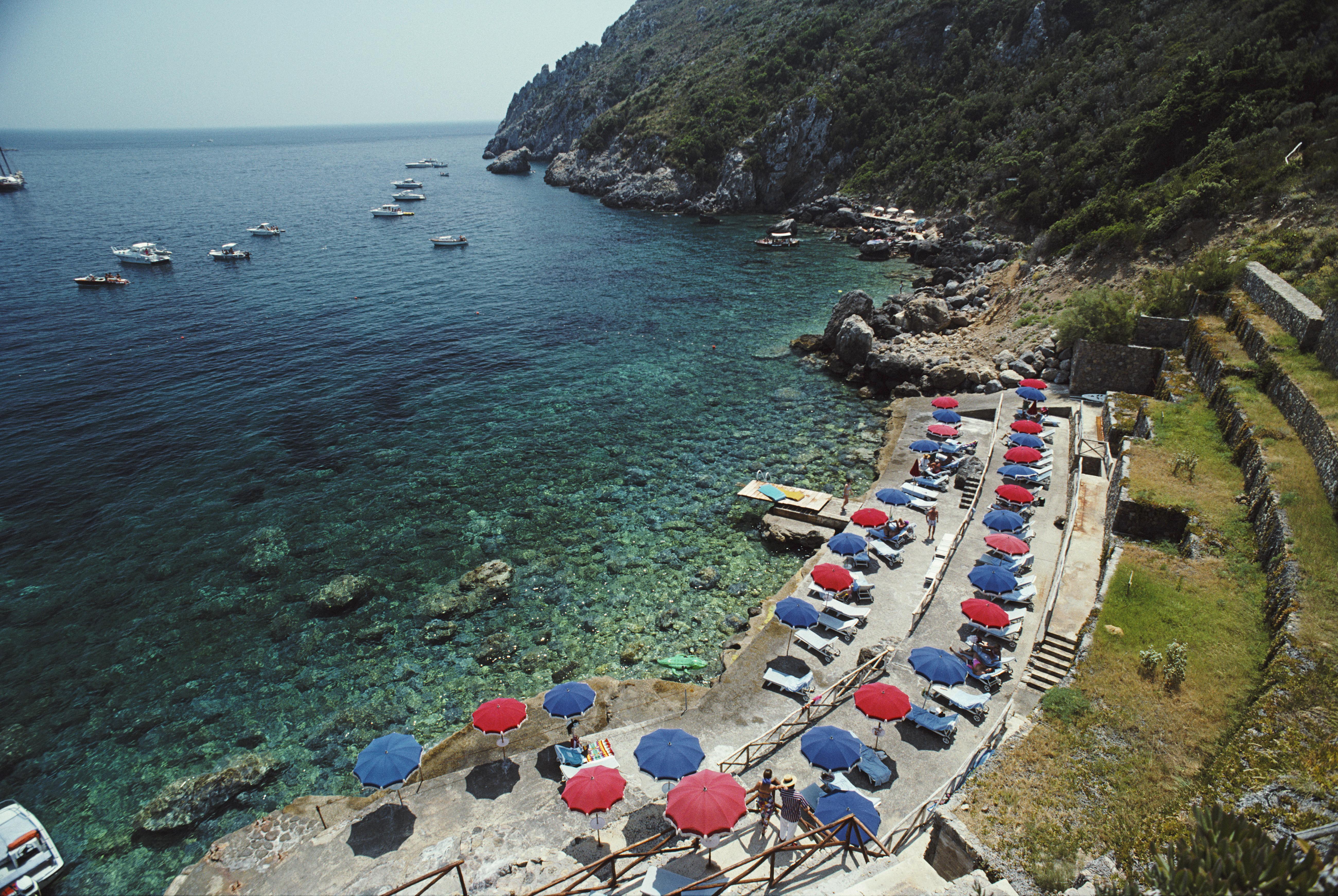 Ein ruhiger Küstenabschnitt in Porto Ercole, Toskana, Juli 1991

Schlanke Aarons
strand von Porto Ercole"
Porto Ercole, Toskana, Italien
Chromogener Lambda-Druck
Später gedruckt
Slim Aarons Estate Edition
Kostenloser Versand durch den Händler an