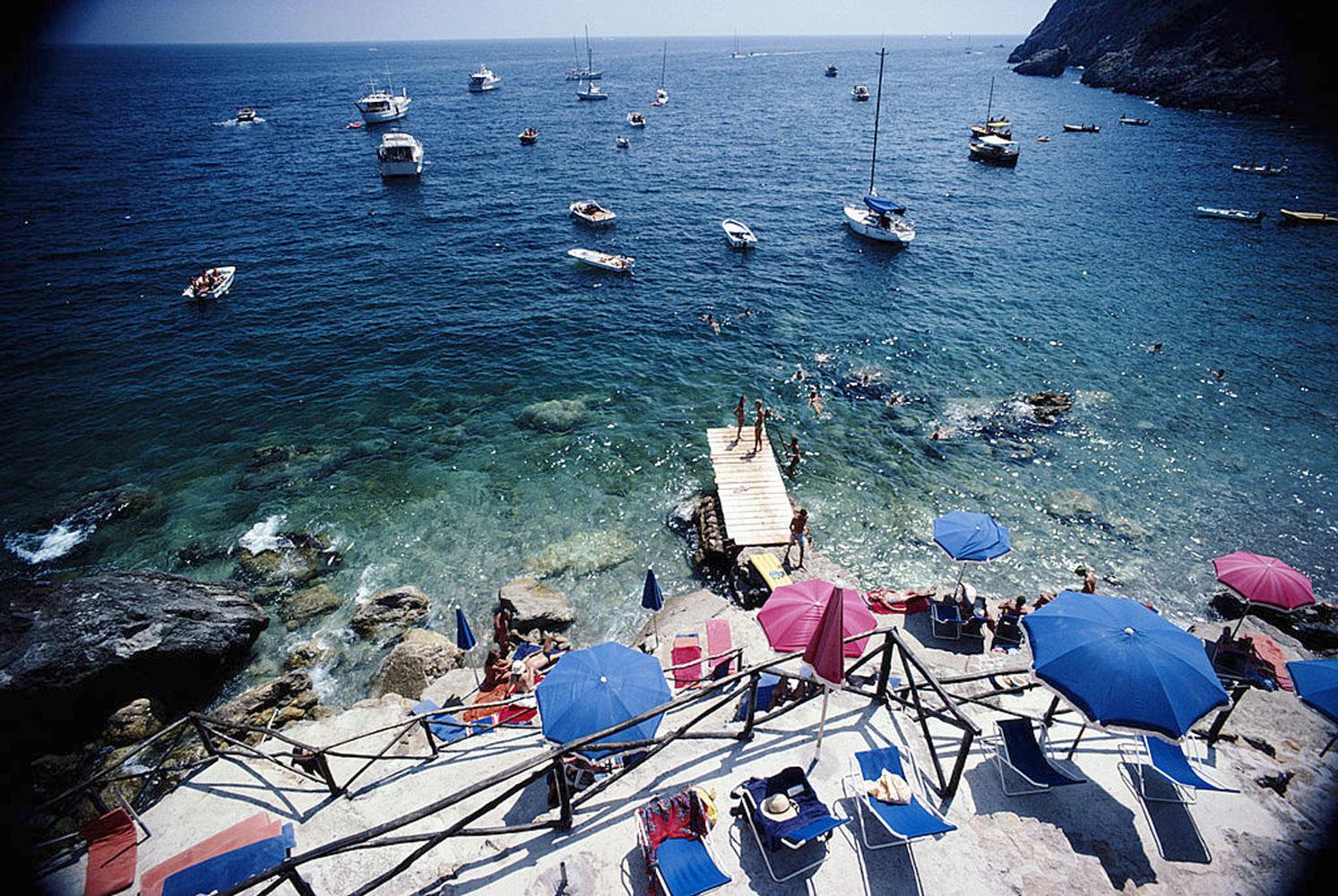 Slim Aarons
Porto Ercole
1980
C print
Estate stamped and hand numbered edition of 150 with certificate of authenticity from the estate.   

A jetty juts out from a rocky shoreline in Porto Ercole, Tuscany, August 1980. 
(Photo by Slim Aarons/Hulton